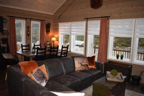 a living room with a leather couch and a dining room at Norbel Hytte Norway in Vradal