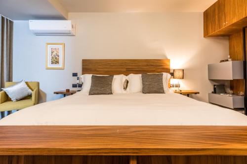 a bedroom with a large bed with a wooden headboard at Casa Olié in Oaxaca City