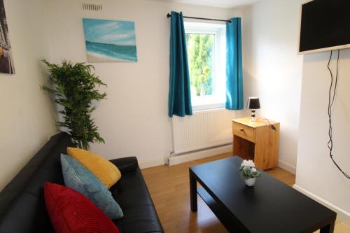 uma sala de estar com um sofá preto e uma mesa em Harvey House em Chesterfield