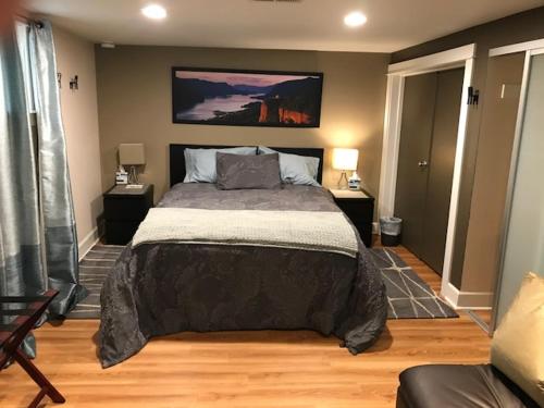 a bedroom with a large bed and two lamps at Boutique Style Apartment in the heart of SE in Portland