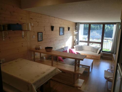 sala de estar con sofá y mesa en Appartement studio front de neige, accès direct aux pistes, en Isola 2000
