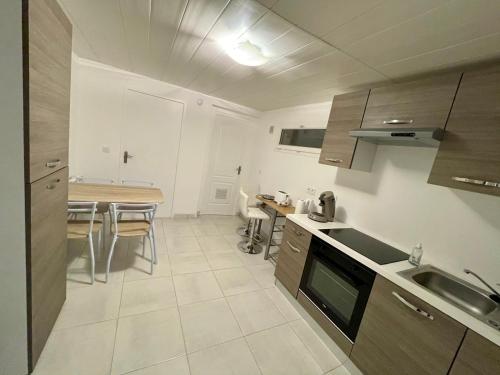 une cuisine avec une table et une salle à manger dans l'établissement Appartement dans maison à Corbelin proche Walibi, à Corbelin