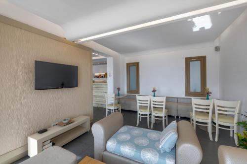 a living room with a couch and a tv at Lithos by Spyros & Flora in Agios Ioannis Mykonos