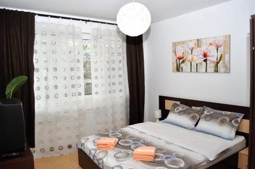 a bedroom with a bed and a window and a television at Gamma Group Accommodation in Bucharest
