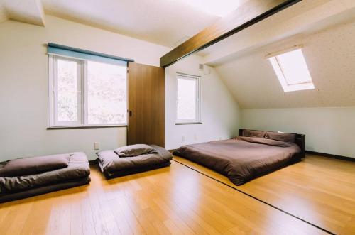 a bedroom with two beds and two windows at Toyako minnpaku - Vacation STAY 16346v in Tōya