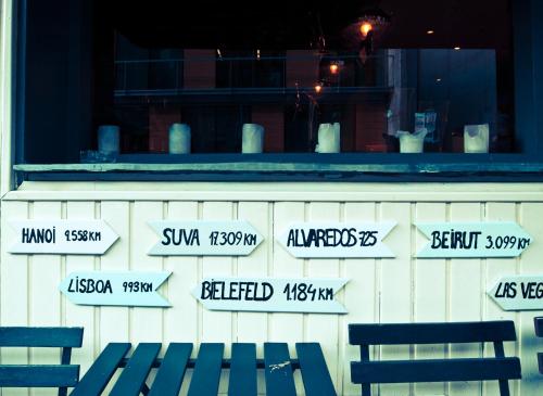 a bench in front of a building with street signs at Barri Antic Hostel & Pub in Andorra la Vella
