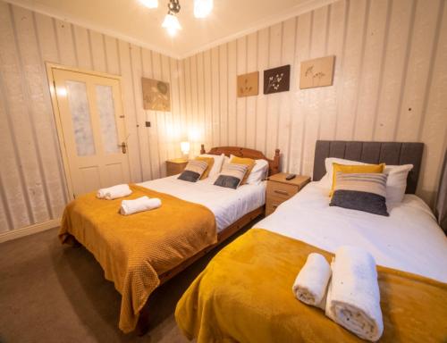 a bedroom with two beds with towels on them at Staveley House in Staveley