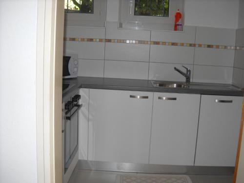 a kitchen with white cabinets and a sink at Casa Alice in Locarno