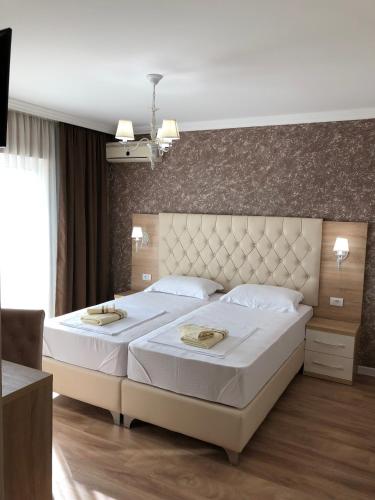 a bedroom with a large bed with a large headboard at "HOLIDAY" apartments & rooms in Ulcinj