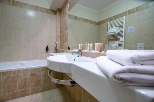 a bathroom with a sink and a tub with towels at Hotel Giovanni Giacomo in Teplice