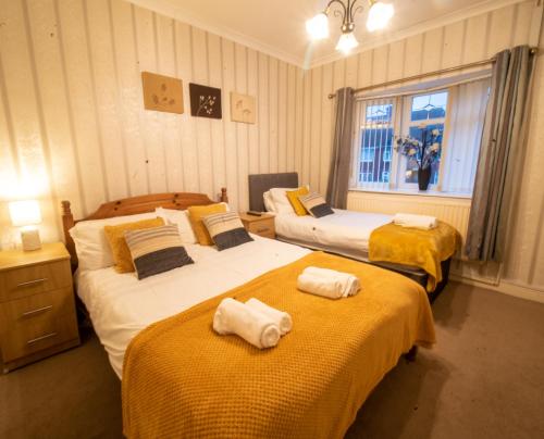 a bedroom with two beds with towels on them at Dryden House in Chesterfield