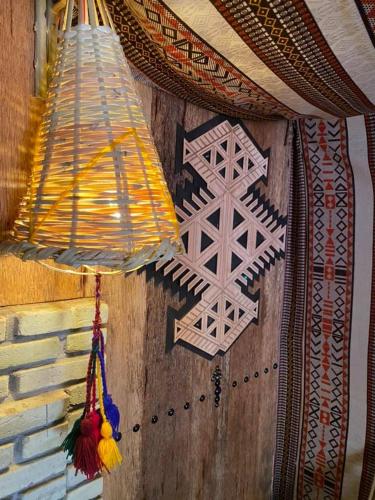a room with a wall with two hanging lights at Tente et Restaurant ElBey in Douz