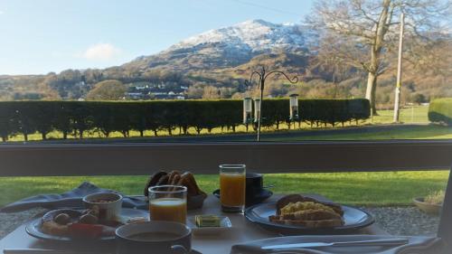 a breakfast table with a view of a mountain at Bluebird Lodge in Coniston