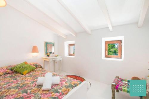 a white bedroom with a bed and a chair at VILLA TOSCANA in Benissa