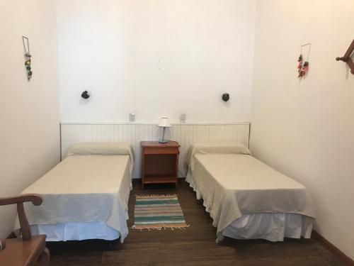 a room with two beds and a table with a lamp at Posada Casa de Borgoña in Salta