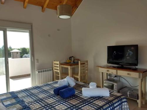 ein Schlafzimmer mit einem Bett mit blauen Kissen und einem TV in der Unterkunft Mirador Suite in Villa General Belgrano