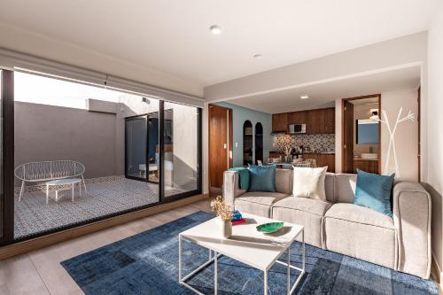 a living room with a couch and a table at Roma Norte Trendy Apartments by VIATO in Mexico City