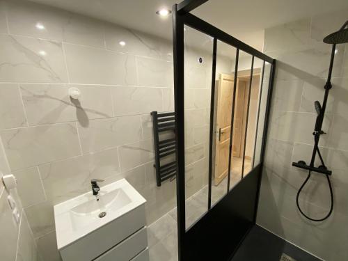 Baño blanco con lavabo y espejo en Chambre privée, en Villiers-en-Bière