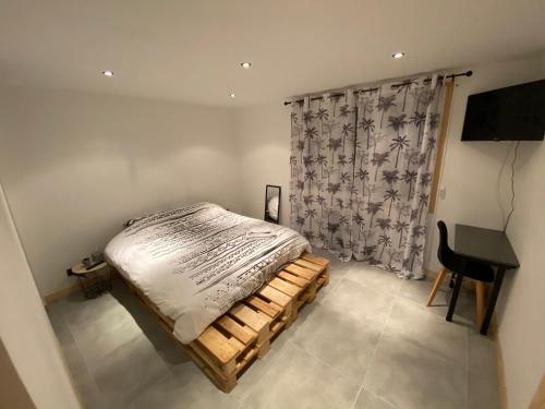 a bedroom with a bed and a desk in it at Chambre privée in Villiers-en-Bière