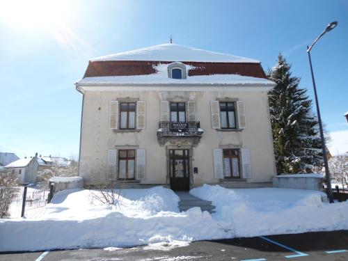 a white house with snow in front of it at Meublé de tourisme in Frasne