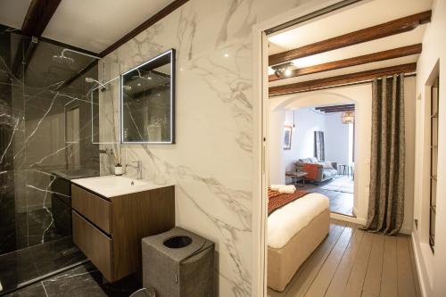 een badkamer met een wastafel en een douche en een slaapkamer bij LaSuitedu12 - Aprtement for 2 people view of the Old Prison in Annecy