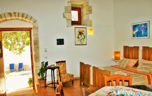 a bedroom with a bed and a table and a chair at Vinciucci in Ispica