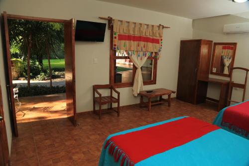 a bedroom with a bed, chair, and desk in it at Hotel El Molino in Río Verde