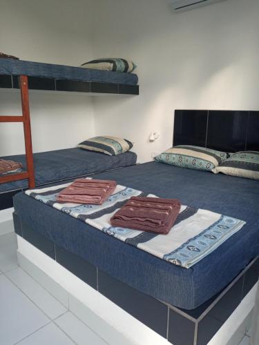 Pousada La Dolce Vita SMG في ساو ميجيل دو غوستوسو: غرفة نوم بسريرين بطابقين مع مناشف عليها
