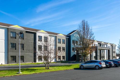 a parking lot with cars parked in front of a building at Aspire Hotel and Suites in Gettysburg