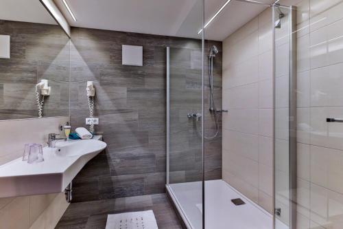 a bathroom with a shower and a sink and a tub at Jugendhotel Bachlehen und Johanneshof in Radstadt