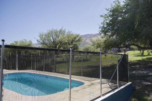 a fence around a swimming pool in a yard at Cabañas Juan Pedro in Los Molles