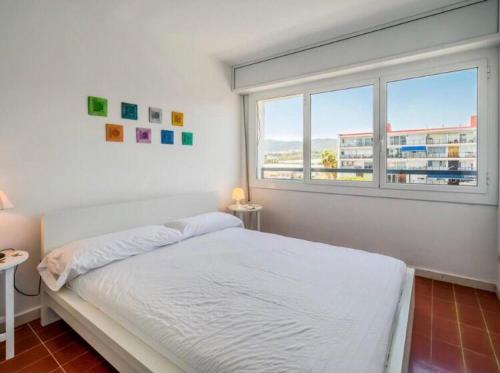 een witte slaapkamer met een bed en een raam bij Can Mabi, 30' Bcn next beach in Vilassar de Mar