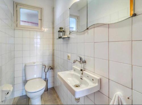 een witte badkamer met een toilet en een wastafel bij Can Mabi, 30' Bcn next beach in Vilassar de Mar