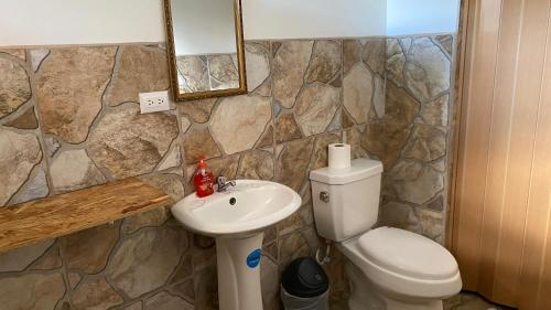 a bathroom with a toilet and a sink at Hotel Your House in Alajuela City