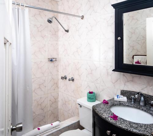 a bathroom with a toilet and a sink and a shower at Legends Beach Resort in Negril