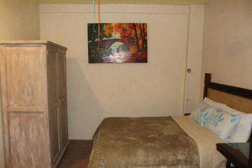 a bedroom with a bed and a painting on the wall at Hotel 19 de Enero Centro in Bernal