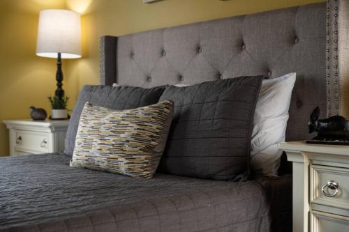 a bed with a gray headboard and a pillow on it at Skyview Villa in Newberg