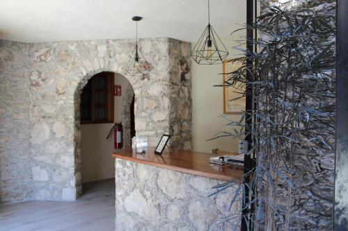 a stone counter in a room with a stone wall at Hotel 19 de Enero Centro in Bernal