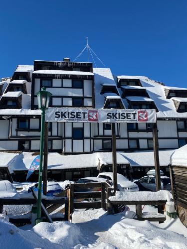 a snow covered building with a sign in front of it at Star Hill - Koznik Konaci in Kopaonik