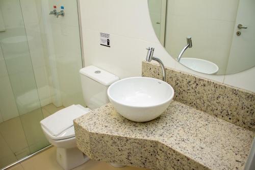 a bathroom with a sink and a toilet at Hotel Seville Comfort in Telêmaco Borba