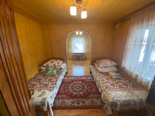 an empty room with two beds in a room at Міні Котедж in Verkhovyna