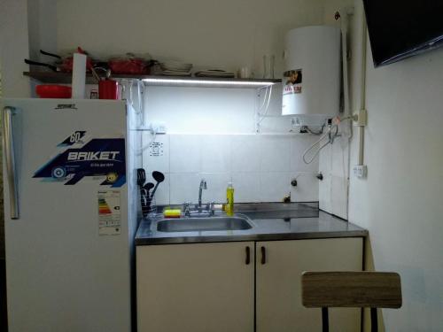 a kitchen with a sink and a refrigerator at Monoambiente confortable a pasos de Bv. Oroño in Rosario