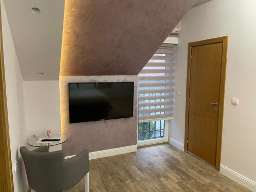 a living room with a flat screen tv on a wall at Villa i SPA Stević in Veliko Gradište