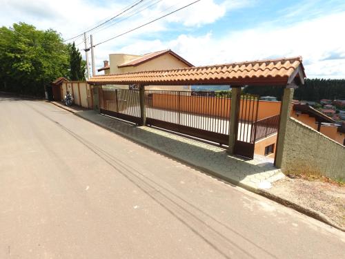 a building with a fence on the side of a road at chalés duas irmãs in Serra Negra