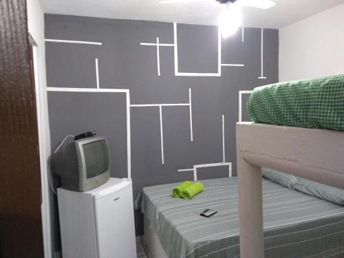 een slaapkamer met een stapelbed en een tv en een bed gmaxwell gmaxwell bij Casa do Mineiro in Nova Viçosa