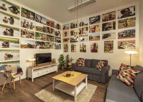 a living room with a large wall of photos at Unesco Prague Apartments in Prague
