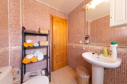 ein Badezimmer mit einem Waschbecken, einem WC und einem Spiegel in der Unterkunft Apartamento en Sur y sol Los Cristianos in Los Cristianos