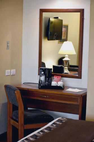 a desk in a hotel room with a mirror at HM Mirador in Chihuahua