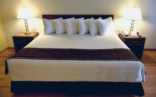 a bedroom with a large bed with two lamps at HM Mirador in Chihuahua