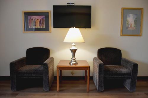 a room with two chairs and a table with a lamp at HM Mirador in Chihuahua